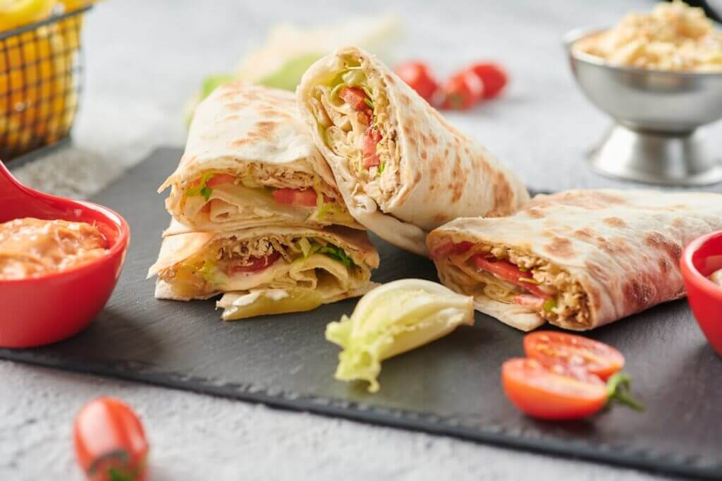 Assiette de wrap poulet​ servis avec une garniture d'avocat et de salsa