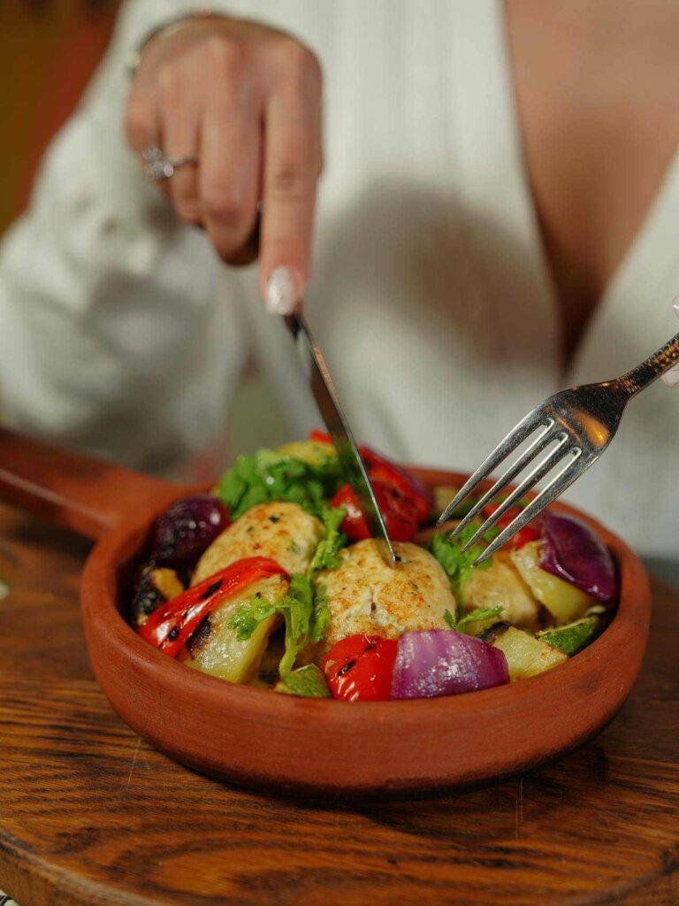 Une assiette de salade colorée avec morceaux de poulet grillé, tomates, concombres, et haricots verts