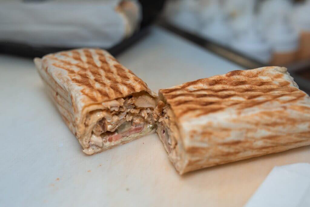 Un wrap au poulet roulé, posé sur une serviette en lin